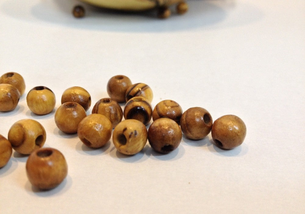 Olive Wood Beads Scattered On Table.